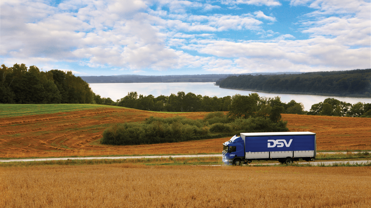 DSV lastebil kjører gjennom landskap.